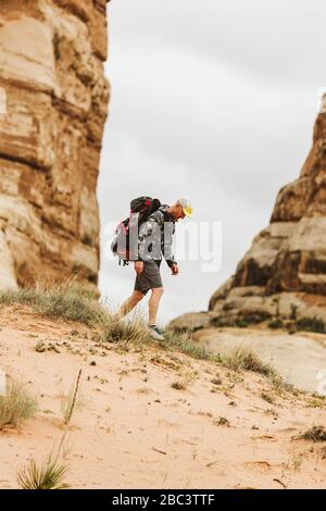 Randonneurs en camouflage et grands randonnées à dos dans le sable dans l'Utah Banque D'Images