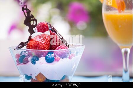 Salade de fruits frais avec glace dans la tasse sur fond coloré Banque D'Images