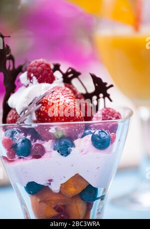 Salade de fruits frais avec glace dans la tasse sur fond coloré Banque D'Images