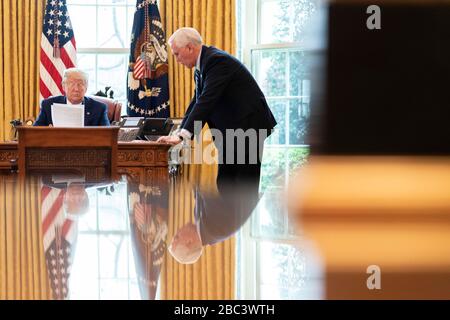 Washington, États-Unis d'Amérique. 01 avril 2020. Washington, États-Unis d'Amérique. 01 avril 2020. Le président américain Donald Trump et le vice-président Mike Pence utilisent le téléphone de l'orateur pour discuter avec les membres de la famille militaire de la COVID-19, pandémie de coronavirus du Bureau ovale de la Maison Blanche le 1er avril 2020 à Washington, DC. Crédit : TIA Dufour/White House photo/Alay Live News Banque D'Images