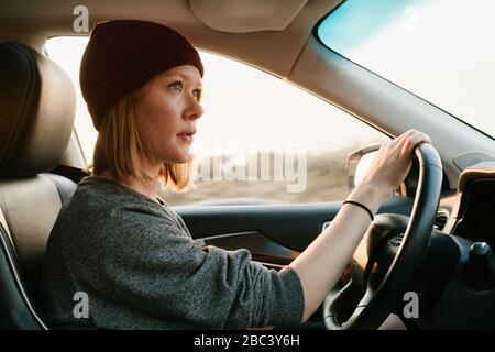 Vue intérieure d'une femme qui conduit à Big sur au coucher du soleil Banque D'Images