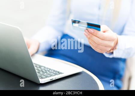 Jeune femme d'affaires utilisant un ordinateur portable et tenant une carte de crédit Banque D'Images