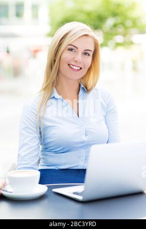 Businesswoman using laptop at cafe Banque D'Images