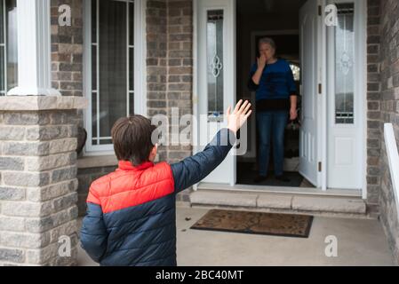 Visite à distance entre le jeune garçon et sa grand-mère à la maison. Banque D'Images