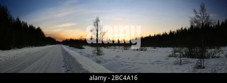 Nuages nacrés le matin sur la route d'hiver et la prairie. Banque D'Images