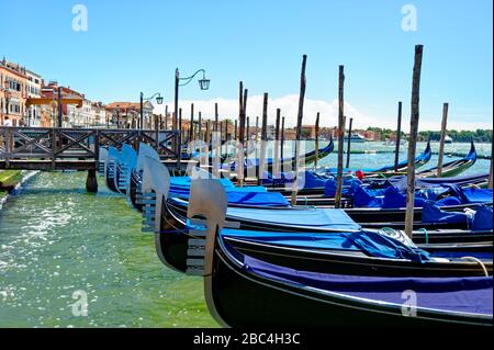 Gondoles amarrées le long de la rive de la lagune de Venise Banque D'Images