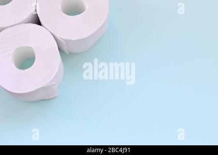 Concept de shopping panpanpanpanpanpanpanpanpandémique de coronavirus. Peu de nouveaux rouleaux de papier toilette sur fond bleu clair. Composition minimaliste de la couche plate avec espace de copie pour Banque D'Images