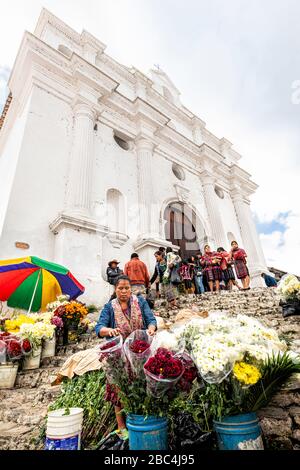 Vendeur de fleurs sur les marches de l'église Saint Thomas à Chichicatenango, au Guatemala. Banque D'Images