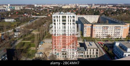 01 avril 2020, Saxe, Leipzig: Les échafaudages ont retiré les échafaudages du premier tiers de la nouvelle "Tour Lipsia". La première tour post-réunification dans le quartier de Granau, bâtiment en plaques de Leipzig, a une place pour 60 appartements sur ses 13 étages. La coopérative d'habitation Lipsia investit 13 millions d'euros. Le projet sans barrière 'Lipsia Tower' est principalement destiné aux locataires plus âgés. Selon les plans actuels, les premiers résidents devraient se déplacer en juillet. Les coopératives d'habitation saxonnes construisent 499 nouveaux appartements à l'échelle nationale en 2020. (Enregistré avec un drone) photo: J Banque D'Images