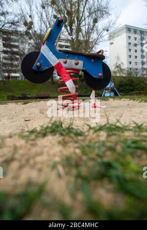 Magdeburg, Allemagne. 02 avril 2020. Le ruban adhésif est suspendu dans une zone verte autour d'un équipement de terrain de jeu qui a la forme d'une moto. En Saxe-Anhalt, les aires de jeux ne peuvent plus être saisies en raison de la propagation du virus coronarien. Crédit: Klaus-Dietmar Gabbert/dpa-Zentralbild/ZB/dpa/Alay Live News Banque D'Images