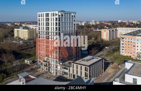 01 avril 2020, Saxe, Leipzig: Les échafaudages ont retiré les échafaudages du premier tiers de la nouvelle "Tour Lipsia". La première tour post-réunification dans le quartier de Granau, bâtiment en plaques de Leipzig, a une place pour 60 appartements sur ses 13 étages. La coopérative d'habitation Lipsia investit 13 millions d'euros. Le projet sans barrière 'Lipsia Tower' est principalement destiné aux locataires plus âgés. Selon les plans actuels, les premiers résidents devraient se déplacer en juillet. Les coopératives d'habitation saxonnes construisent 499 nouveaux appartements à l'échelle nationale en 2020. (Enregistré avec un drone) photo: J Banque D'Images