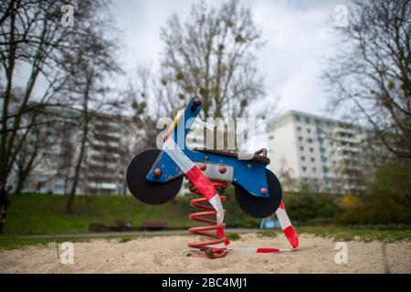 Magdeburg, Allemagne. 02 avril 2020. Le ruban adhésif est suspendu dans une zone verte autour d'un équipement de terrain de jeu qui a la forme d'une moto. En Saxe-Anhalt, il n'est pas permis d'entrer plus de terrains de jeux en raison de la propagation du virus coronarien. Crédit: Klaus-Dietmar Gabbert/dpa-Zentralbild/ZB/dpa/Alay Live News Banque D'Images