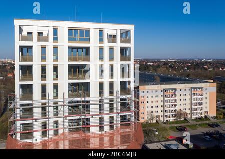 01 avril 2020, Saxe, Leipzig: Les échafaudages ont retiré les échafaudages du premier tiers de la nouvelle "Tour Lipsia". La première tour post-réunification dans le quartier de Granau, bâtiment en plaques de Leipzig, a une place pour 60 appartements sur ses 13 étages. La coopérative d'habitation Lipsia investit 13 millions d'euros. Le projet sans barrière 'Lipsia Tower' est principalement destiné aux locataires plus âgés. Selon les plans actuels, les premiers résidents devraient se déplacer en juillet. Les coopératives d'habitation saxonnes construisent 499 nouveaux appartements à l'échelle nationale en 2020. (Enregistré avec un drone) photo: J Banque D'Images