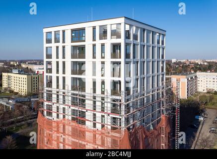 01 avril 2020, Saxe, Leipzig: Les échafaudages ont retiré les échafaudages du premier tiers de la nouvelle "Tour Lipsia". La première tour post-réunification dans le quartier de Granau, bâtiment en plaques de Leipzig, a une place pour 60 appartements sur ses 13 étages. La coopérative d'habitation Lipsia investit 13 millions d'euros. Le projet sans barrière 'Lipsia Tower' est principalement destiné aux locataires plus âgés. Selon les plans actuels, les premiers résidents devraient se déplacer en juillet. Les coopératives d'habitation saxonnes construisent 499 nouveaux appartements à l'échelle nationale en 2020. (Enregistré avec un drone) photo: J Banque D'Images