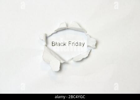 Mot noir vendredi sur fond blanc isolé, l'inscription à travers le trou de la plaie dans le papier. Stocker la photo pour le Web et l'imprimer avec un espace vide pour le texte et la conception. Banque D'Images
