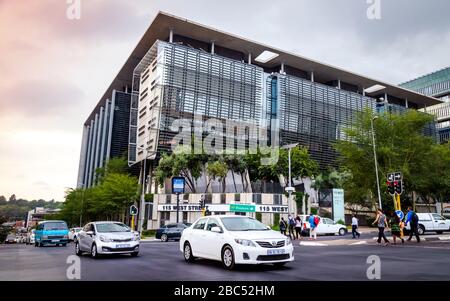 Johannesburg, Afrique du Sud 18 février - 2020: Intersection avec les voitures passant devant le bâtiment des bureaux d'entreprise. Banque D'Images