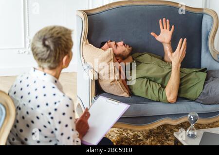 Patient masculin sérieux parlant à son médecin Banque D'Images