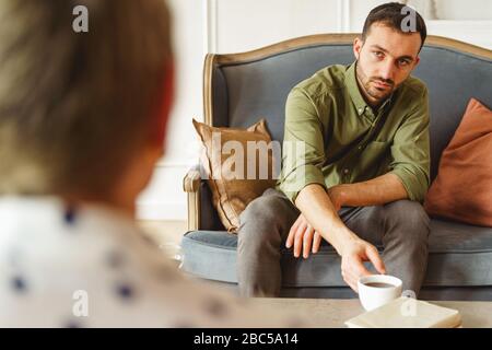 Homme atteignant pour une tasse de tisanes Banque D'Images