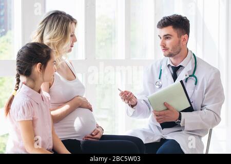 Médecin consultant femme enceinte avec fille en clinique Banque D'Images