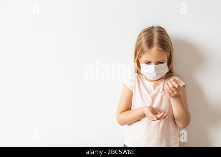 Petite fille caucasienne utilisant du gel d'alcool désinfectant pour les mains pour une hygiène des mains propre prévention de l'éclosion du virus du coronavirus. Garder les mains propres pendant Banque D'Images