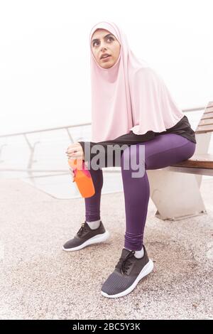 Femme de sport assise sur la photo de banc Banque D'Images