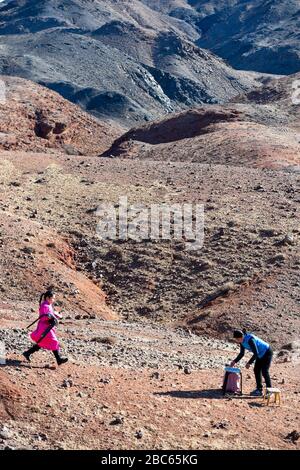 (200403) -- ALXA, le 3 avril 2020 (Xinhua) -- ce Geng (L) cherche un abri du vent pour prendre des cours en ligne avec la compagnie de sa mère à Alxa Left Banner, région autonome de la Mongolie intérieure nord, le 1er avril 2020. Ce Geng, un quatrième niveleur de 9 ans d'une école mongole à Alxa Left Banner, s'est déplacé ici avec ses parents pour s'occuper des moutons comme le berger qu'ils avaient embauché d'autres provinces n'a pas pu revenir en raison de l'éclosion de COVID-19. Le ranch de la famille est situé près de la frontière entre la Chine et la Mongolie, dans la partie nord d'Alxa, à plus de 6 heures de route du centre-ville d'Alxa L Banque D'Images