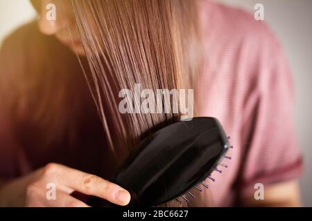 Femme brossant ses beaux cheveux marron sains Banque D'Images