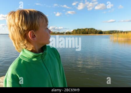 Vue de profil de jeune beau garçon regardant la vue de la rivière Banque D'Images