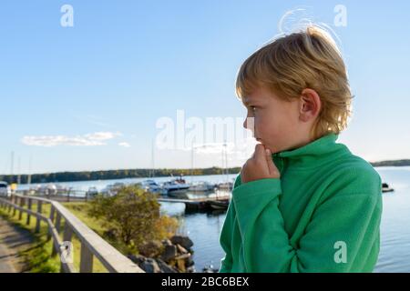 Vue sur le profil de jeune beau garçon à la jetée en bois près de la rivière Banque D'Images