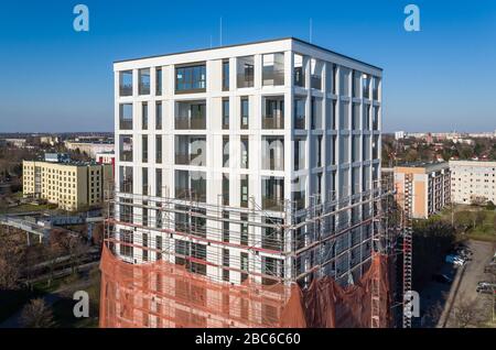 01 avril 2020, Saxe, Leipzig: Les échafaudages ont retiré les échafaudages du premier tiers de la nouvelle "Tour Lipsia". La première tour post-réunification dans le quartier de Granau, bâtiment en plaques de Leipzig, a une place pour 60 appartements sur ses 13 étages. La coopérative d'habitation Lipsia investit 13 millions d'euros. Le projet sans barrière 'Lipsia Tower' est principalement destiné aux locataires plus âgés. Selon les plans actuels, les premiers résidents devraient se déplacer en juillet. Les coopératives d'habitation saxonnes construisent 499 nouveaux appartements à l'échelle nationale en 2020. (Enregistré avec un drone) photo: J Banque D'Images