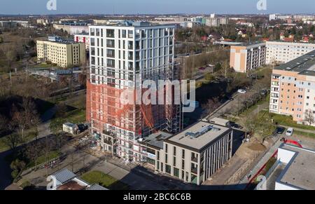 01 avril 2020, Saxe, Leipzig: Les échafaudages ont retiré les échafaudages du premier tiers de la nouvelle "Tour Lipsia". La première tour post-réunification dans le quartier de Granau, bâtiment en plaques de Leipzig, a une place pour 60 appartements sur ses 13 étages. La coopérative d'habitation Lipsia investit 13 millions d'euros. Le projet sans barrière 'Lipsia Tower' est principalement destiné aux locataires plus âgés. Selon les plans actuels, les premiers résidents devraient se déplacer en juillet. Les coopératives d'habitation saxonnes construisent 499 nouveaux appartements à l'échelle nationale en 2020. (Enregistré avec un drone) photo: J Banque D'Images