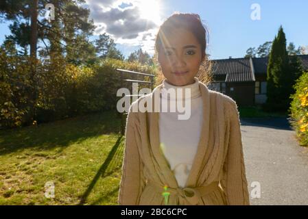 Jeune femme asiatique belle dans la cour avant à la maison Banque D'Images