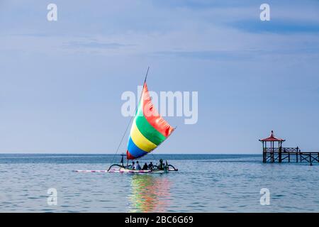 Les touristes qui prennent un bateau dans UN bateau à voile indonésien traditionnel (Jukung), près de Situbondo, Java, Indonésie Banque D'Images