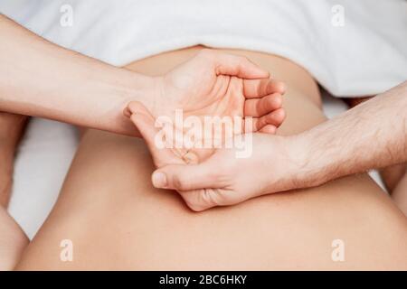 Les paumes des mains sur le dos humain en massant pendant les mains montrent yin et yang. Banque D'Images