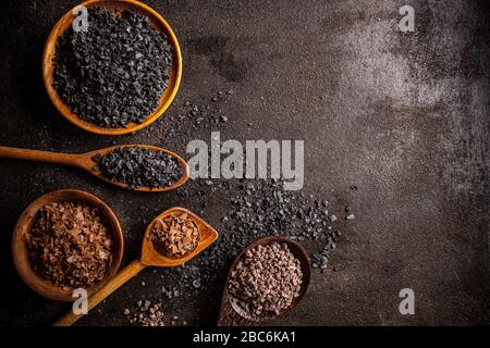 Différents types de sel sur fond sombre grungy avec de l'espace pour votre texte Banque D'Images