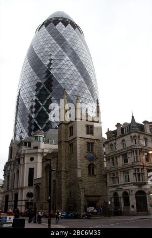 La grande structure en verre du Gherkin, derrière l'église St Helen, illustre l'ancienne et nouvelle architecture de la ville de Londres Banque D'Images