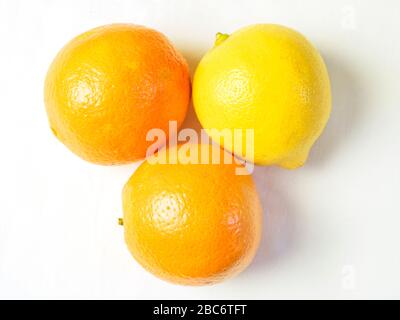 Deux oranges et un citron d'en haut sur une nappe blanche Banque D'Images