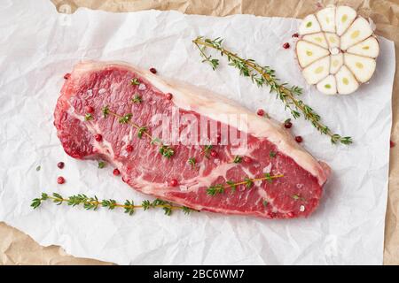 Gros morceau entier de viande de boeuf brute, stripline sur papier parchemin blanc Banque D'Images