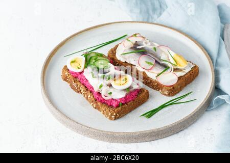 Smorrebrod de poisson salé, jeu de cinq sandwichs traditionnels danois. Pain de seigle noir Banque D'Images
