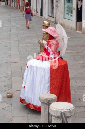 Venise, Italie - 30 juin 2017: Deux personnes en femme rouge vêtements vénitiens, homme en vêtements de couleur dorée dans la rue, photographié d'en haut à Venise, Banque D'Images