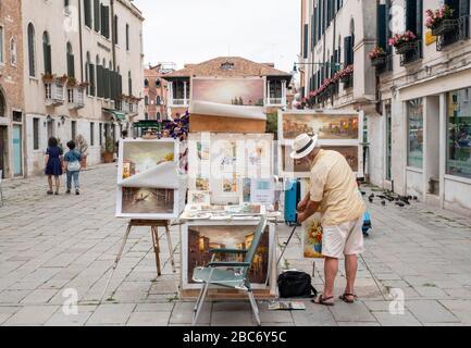 Venise, Italie - 30 juin 2017: Un artiste de rue masculin est suspendu une photo dans son stand à Venise, Italie. Banque D'Images