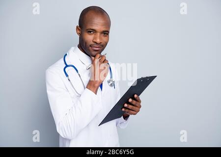 Photo du médecin de famille professionnel la peau sombre gars tenir stylo patient presse-papiers prescription test lecture assurance pharmacie porter labo manteau cou cravate Banque D'Images