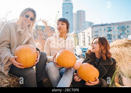 Les filles tient les citrouilles dans les mains sur le fond de la rue. Banque D'Images