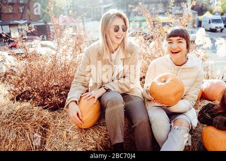 Les filles tient les citrouilles dans les mains sur le fond de la rue. Banque D'Images