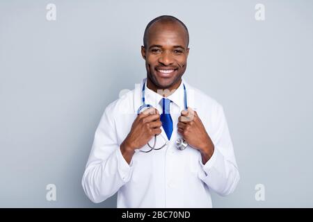 Photo du médecin de famille peau sombre gars à l'écoute du patient virologue gai beaming sourire joyeux prêt à dire conseils porter blanc blouse de laboratoire bleu cravate de cou Banque D'Images