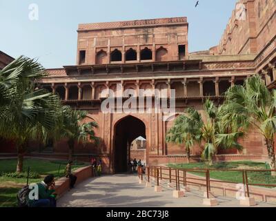 Agra, Inde - Mars 2018: Entrée impressionnante au fort Red Agra, avec des gens assis sur les côtés de la passerelle. Banque D'Images