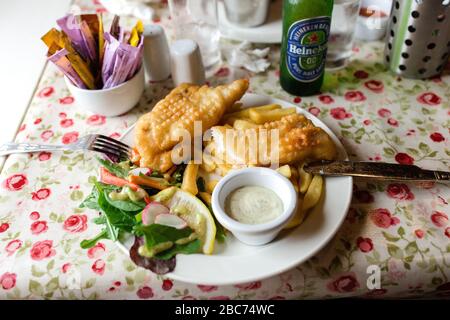 Assiette de poisson et de chips servies avec de la laitue, une tranche de sauce au citron et au tartre trempée au Campbell au pub Reek à Westport, en Irlande Banque D'Images