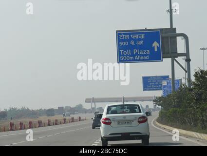 Yamuna Expressway, Inde - Mars 2018: Panneaux de direction sur la route qui approche un péage plaza. Banque D'Images
