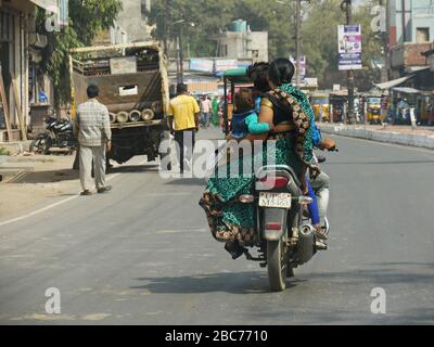 Mathura, Uttar Pradesh, Inde - Mars 2018: Une famille se déplace en une seule moto qui se déplace le long de la route à Mathura. Banque D'Images