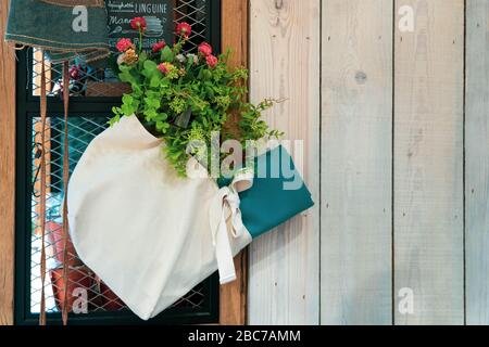 Plantez à l'intérieur d'un sac fourre-tout décoré accroché sur un mur de retenue en acier. Banque D'Images